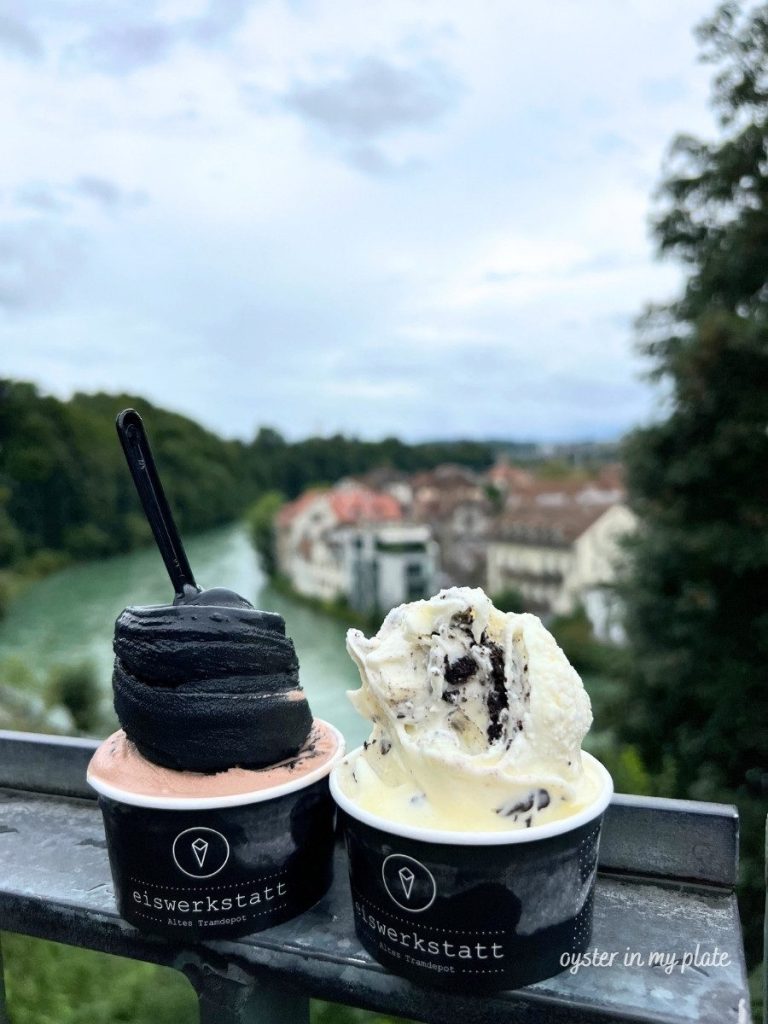 아래강을 배경으로 부드럽고 진한 블랙 바닐라 아이스크림이 담긴 컵.