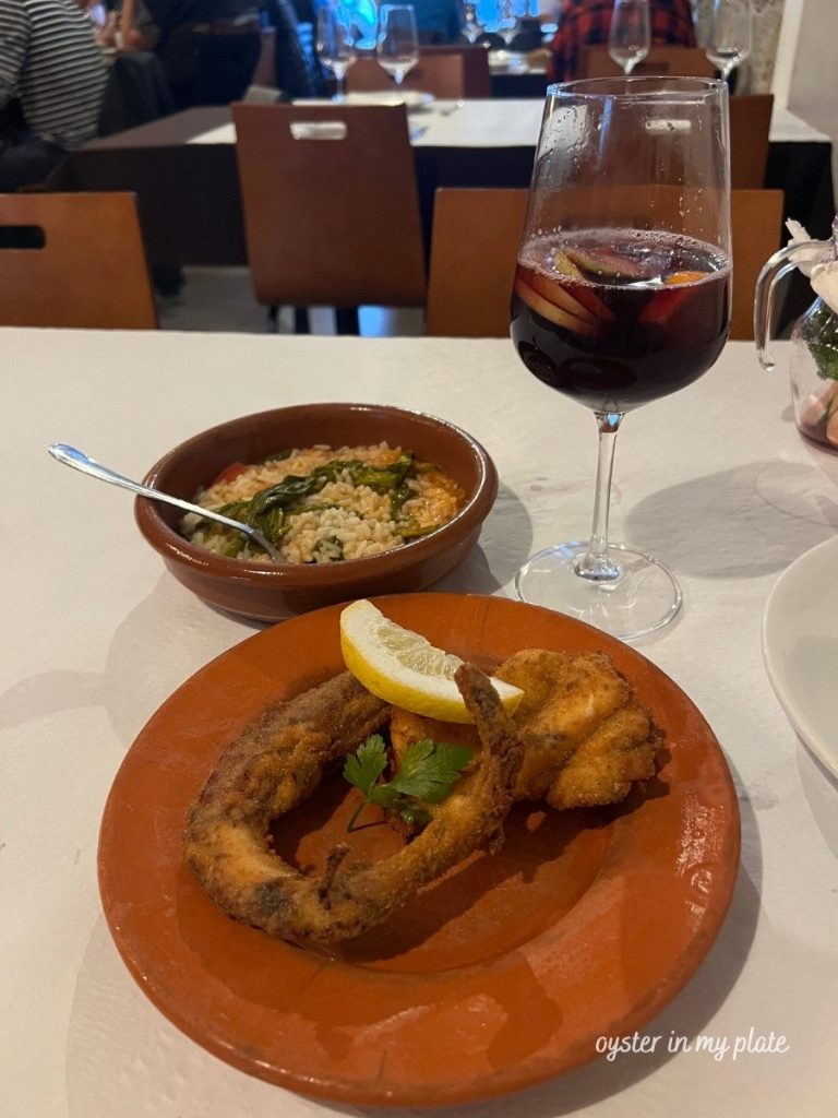 fried octopus and seafood rice with a glass of sangria on a restaurant a Taska in Portugal